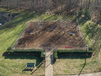 A garden with a fence and a bench is shown from an aerial view.